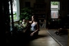 Morgan, the primary caregiver for her boyfriend, waters their houseplants.