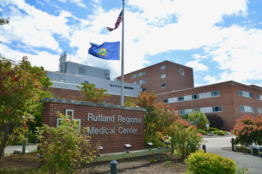 Photo of red brick hospital building with American and Vermont flag flying.